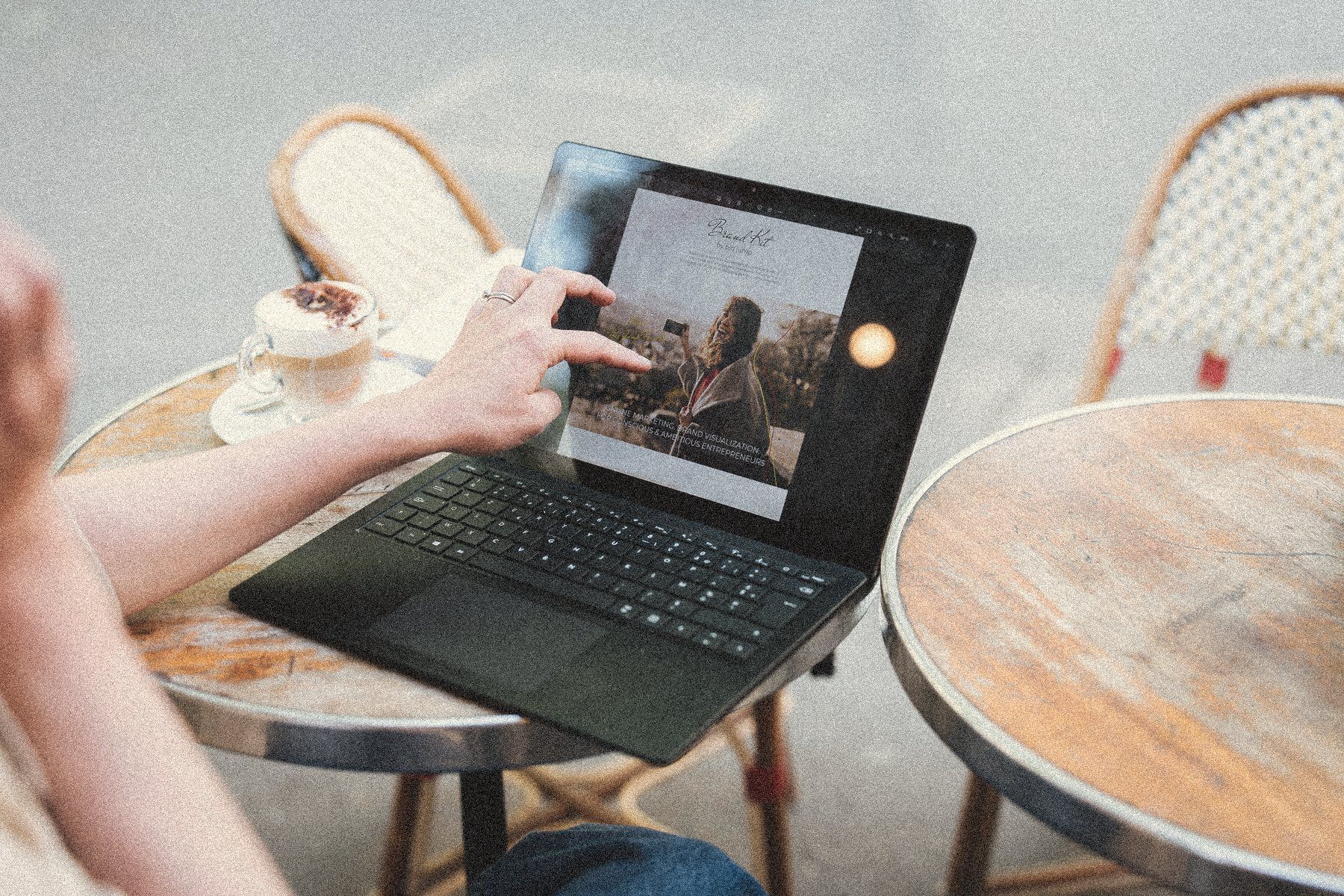 Aliya's hands on a laptop at a Paris café table